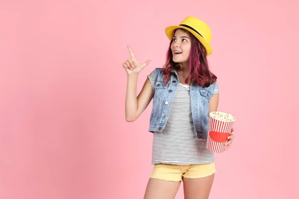 Jong meisje in mode kleding holding emmer met popcorn op pi — Stockfoto