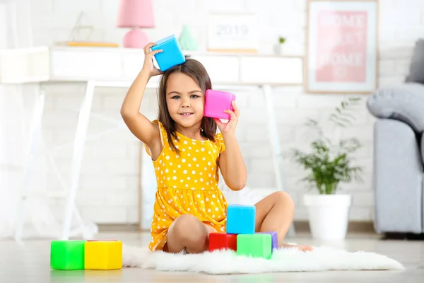 Mooi klein meisje spelen met plastic speelgoed thuis — Stockfoto