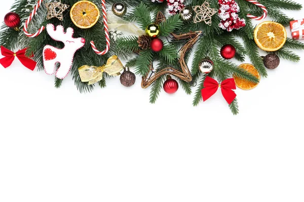 Kerstboom takken met speelgoed en oranje fruit op witte rug — Stockfoto