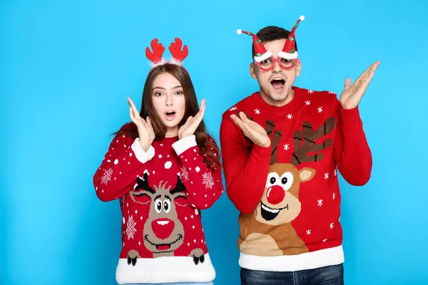 Hermoso hombre y mujer que usan suéteres de Navidad con cuerno rojo — Foto de Stock