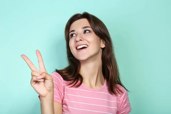 Mujer joven en camiseta rosa sobre fondo de menta — Foto de Stock