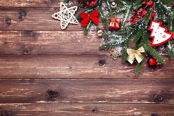 クリスマスツリーの枝におもちゃで茶色の木製のテーブル — ストック写真