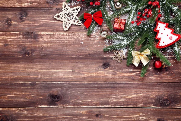 Christmas tree branches with toys on brown wooden table — Stock Photo, Image