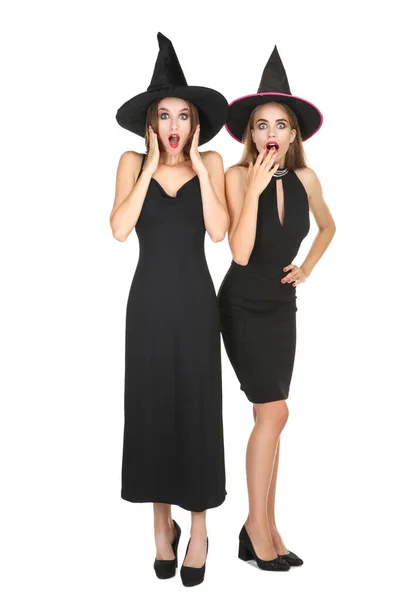 Twee jonge verbaasd vrouwen in zwart halloween kostuums op wit b — Stockfoto