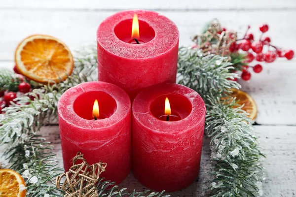 Velas de Navidad con naranjas secas y ramas de abeto en el blanco — Foto de Stock