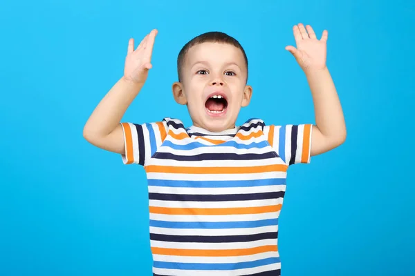 Emocionální malý chlapec na modrém pozadí — Stock fotografie