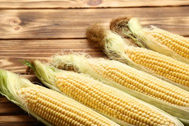 Kahverengi ahşap masada olgun mısır.