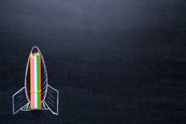 Karatahtaya renkli pastel boyalarla roket çizimi