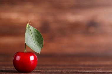 Kahverengi ahşap masada yeşil yapraklı tatlı kiraz