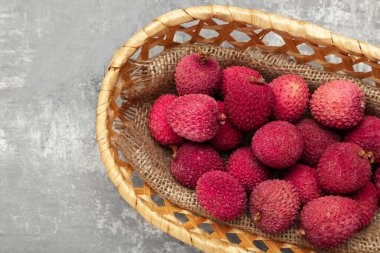 Gri arka planda sepetteki lezzetli liçi.