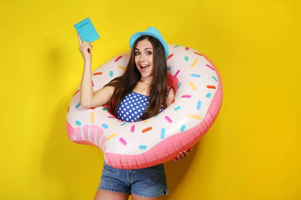Junges Mädchen Mit Aufblasbarem Donut Und Pass Auf Gelbem Hintergrund — Stockfoto