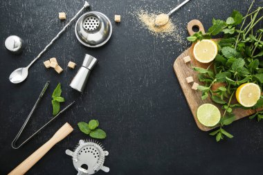 Barmen ekipmanları limonlu, limonlu ve siyah ahşap masada nane yapraklı.