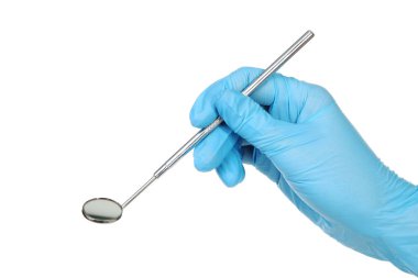 Eldivenli doktor beyaz arka planda diş aletini tutuyor.