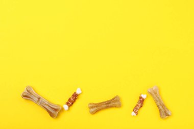 Sarı arka planda kemik şeklinde kuru hayvan maması.