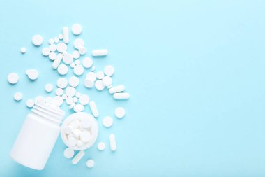 Mavi arka planda ilaç hapları ve şişeler