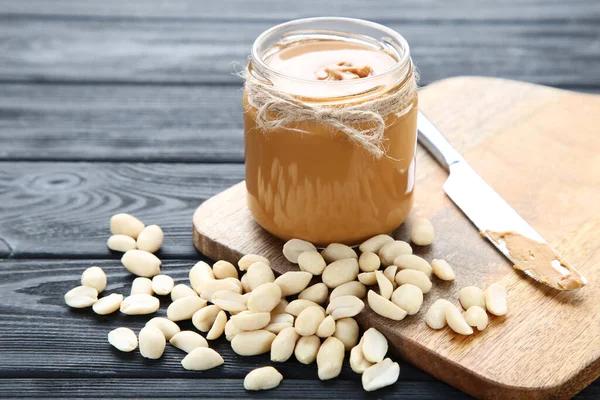 Erdnussbutter Glas Und Nüsse Auf Schwarzem Holztisch — Stockfoto