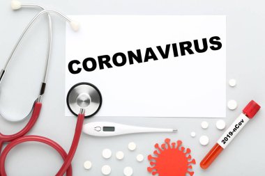 Coronavirus 'a steteskop, hap, termometre ve gri arka planda test tüpü kullan.