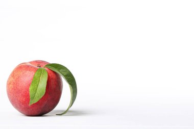 Beyaz arka planda yeşil yapraklı taze şeftali