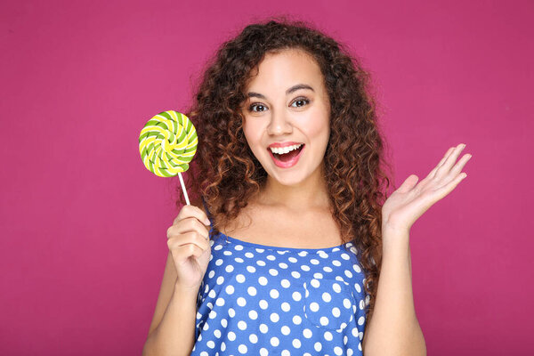 Удивлённая американка с леденцом на розовом фоне
