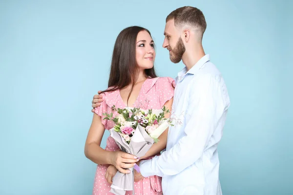 Feliz Pareja Joven Con Ramo Flores Sobre Fondo Azul — Foto de Stock