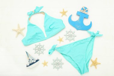 Deniz yıldızlı mayo, dekoratif gemi, çapa ve direksiyon beyaz ahşap masa