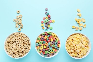 Mavi arka planda kaselerde çeşitli mısır gevrekleri