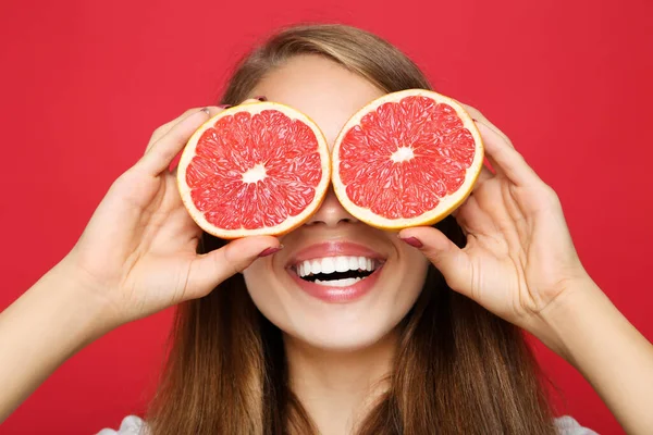 Mladá Dívka Čerstvým Grapefruitem Červeném Pozadí — Stock fotografie