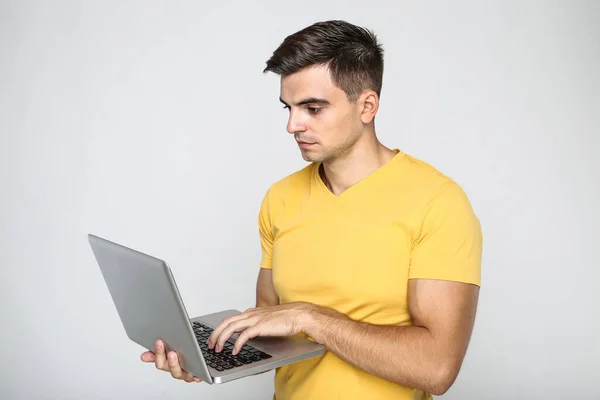 Молодий Чоловік Працює Комп Ютерному Ноутбуці Сірому Фоні — стокове фото