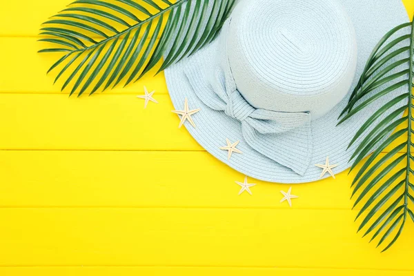 Zomerstrohoed Met Groene Palmbladeren Gele Houten Achtergrond — Stockfoto