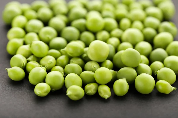 黒の背景に緑のエンドウ豆 — ストック写真