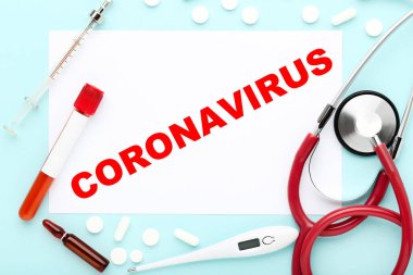 Coronavirus 'u steteskop, termometre, haplar, test tüpü ve şırıngayla mavi arkaplana gönder.