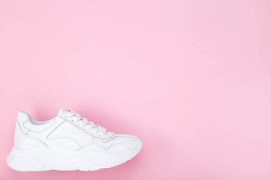 Pembe arka planda beyaz ayakkabı