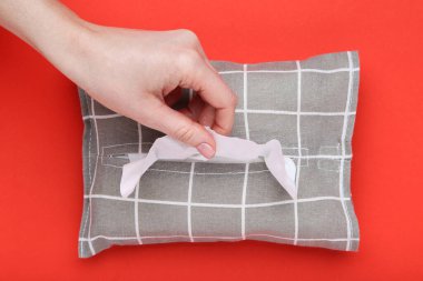 Kırmızı arka planda kadın eli olan peçete kutusu