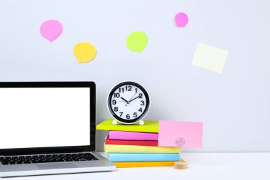 Kitaplı dizüstü bilgisayar, yuvarlak saat ve gri arkaplanda boş konuşma baloncukları