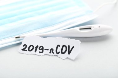 Metin 2019-nCov tıp maskesi ve gri arkaplan termometresiyle