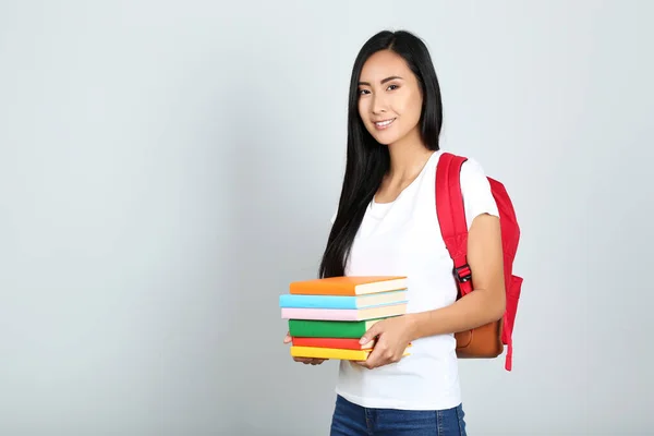 Mujer Joven Con Pila Libros Mochila Sobre Fondo Gris — Foto de Stock