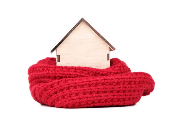 Wooden house model with red knitted scarf isolated on white background