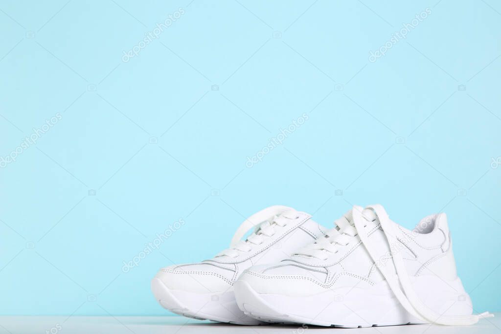 Pair of white shoes on blue background