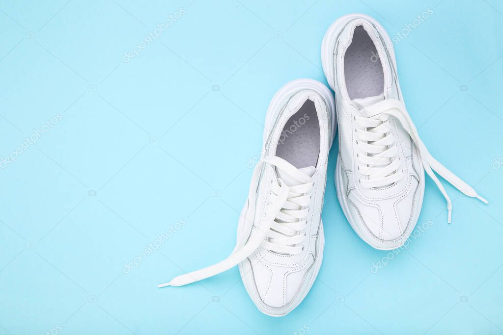 Pair of white shoes on blue background