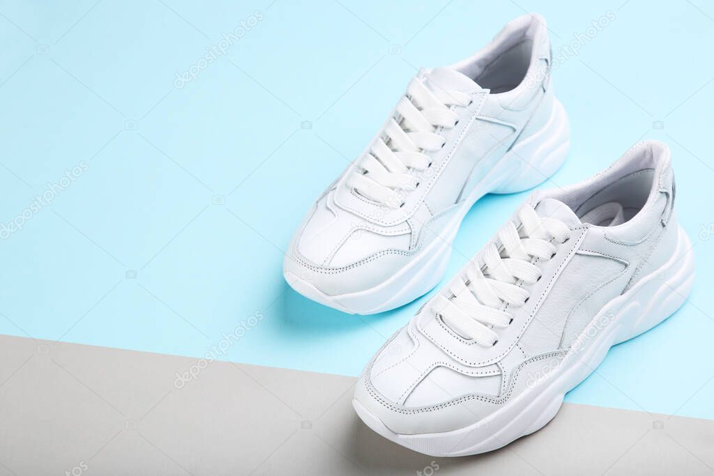 Pair of white shoes on blue and grey background