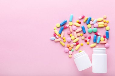 Pembe arka planda renkli haplar ve şişeler