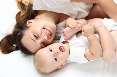 Genç anne ve erkek bebek yatakta yatıyor.