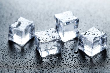 Siyah arkaplanda su damlaları olan buz küpleri