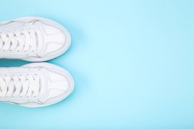 Mavi arkaplanda bir çift beyaz ayakkabı