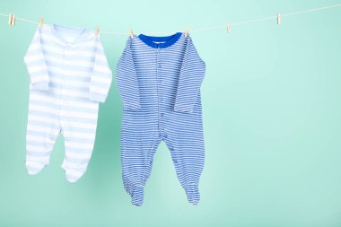Mavi arka planda asılı bebek kıyafetleri