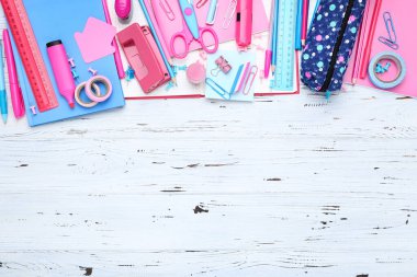 Beyaz ahşap arka planda farklı okul malzemeleri.