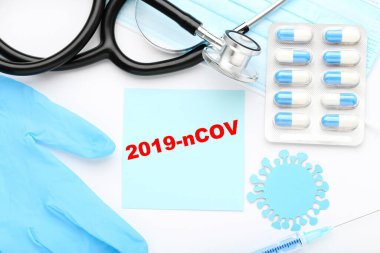Metin 2019-nCov haplar, steteskop, ilaç eldivenleri ve beyaz arka planda şırınga