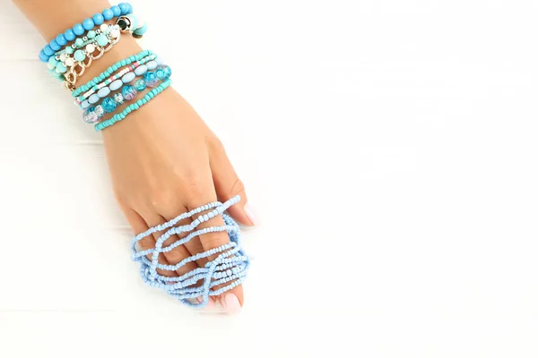 Mano Femenina Con Pulseras Azules Sobre Fondo Blanco Madera — Foto de Stock