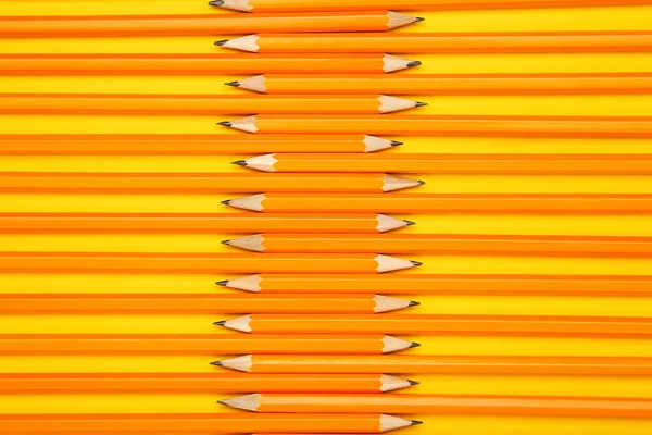 Yellow pencils on yellow background