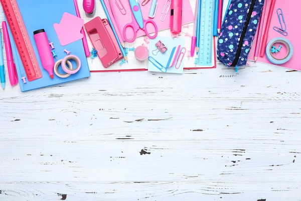 Beyaz ahşap arka planda farklı okul malzemeleri.